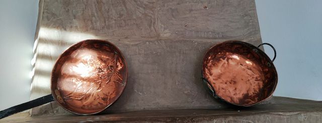 Piezas de cobre antiguas, sartenes y olla