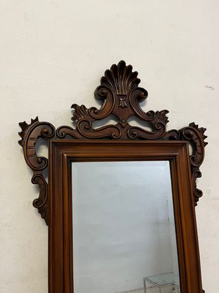 Espejo tallado en madera con cristal biselado.