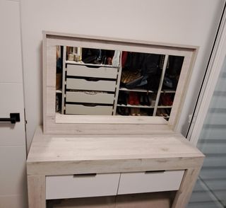 Mueble de recibidor junto a espejo.