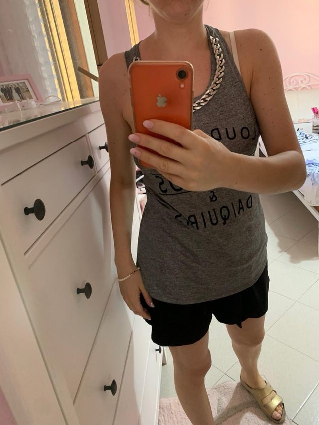 Canotta grigia con scritte nere e catena grigia