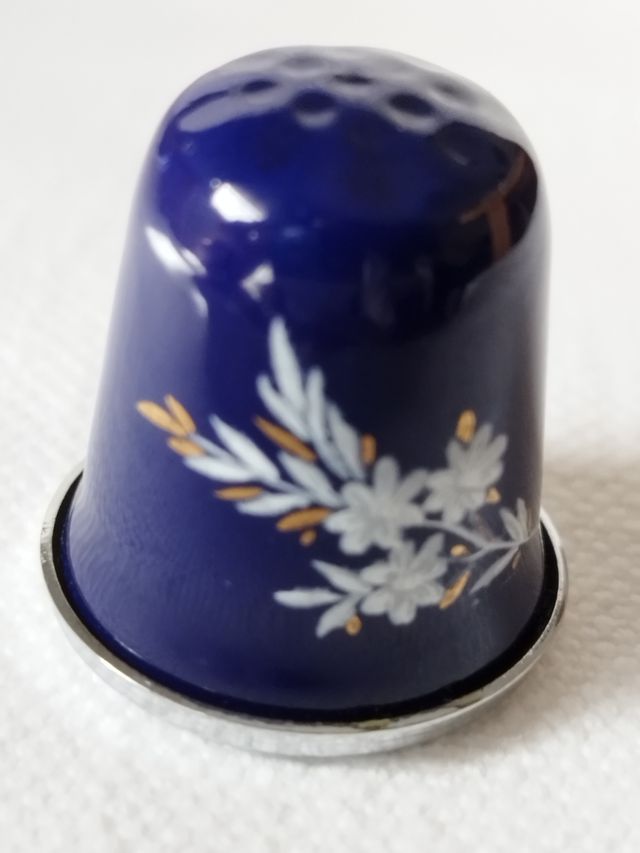 dedal de metal plateado con esmalte azul