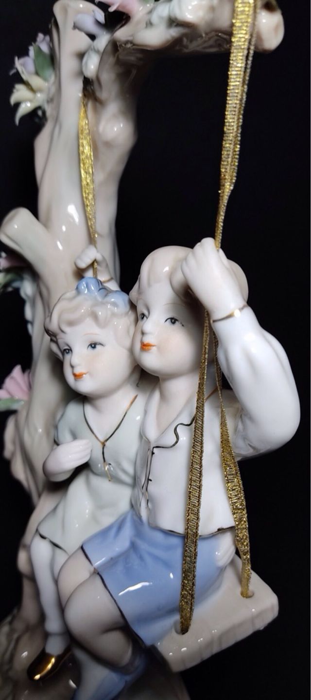 Figura porcelana, niños en columpio. 30x15. OFERTA