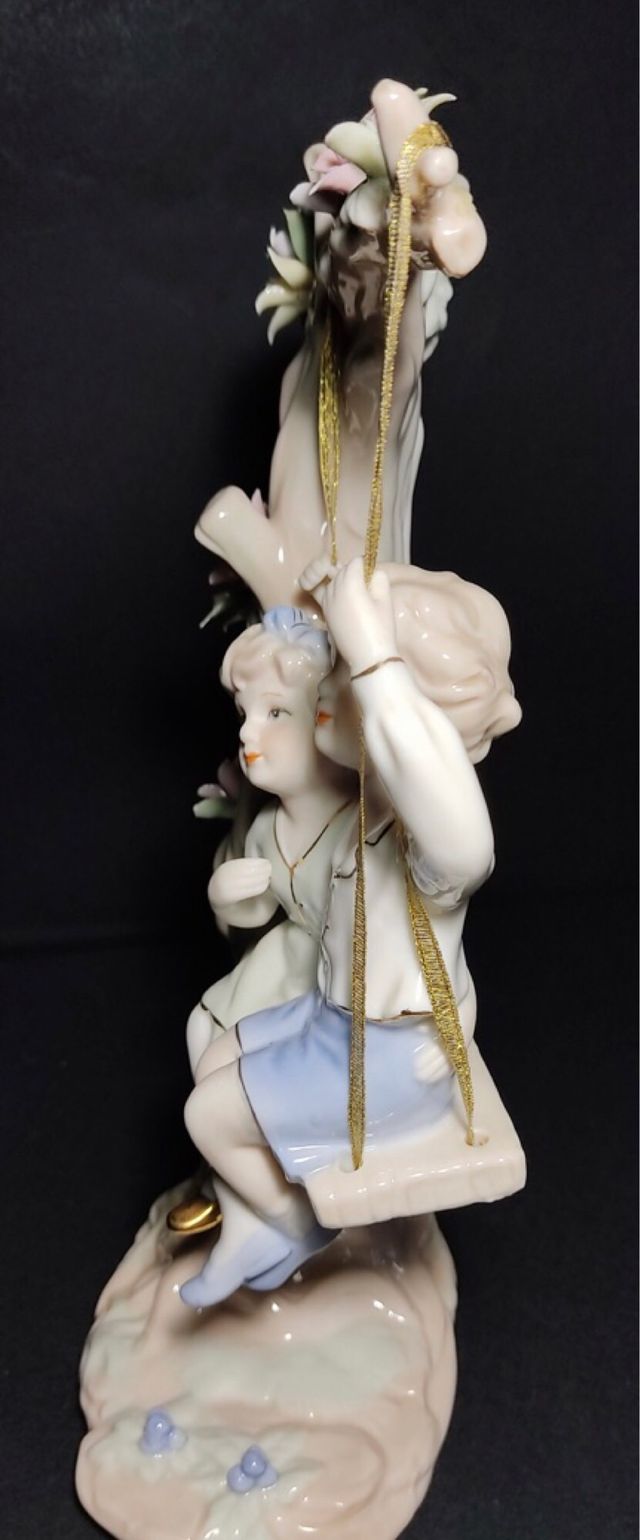 Figura porcelana, niños en columpio. 30x15. OFERTA