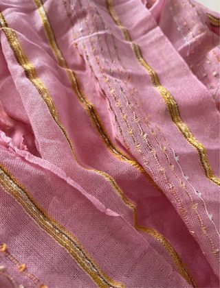 Sciarpa rosa con frange, fili bianchi e colorati.