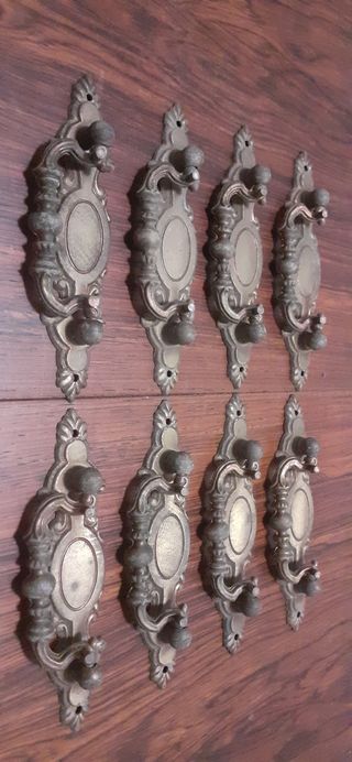 8 tiradores antiguos de metal patinado en bronce.