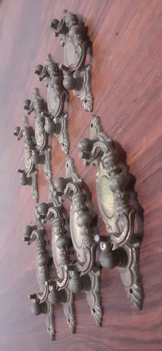 8 tiradores antiguos de metal patinado en bronce.