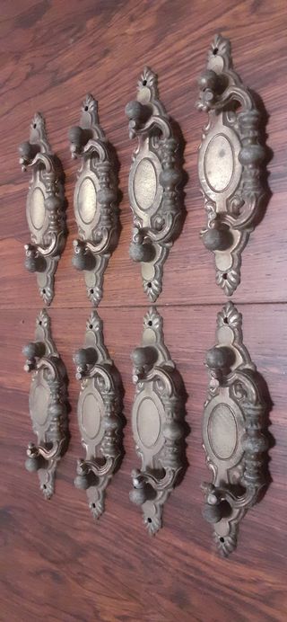 8 tiradores antiguos de metal patinado en bronce.