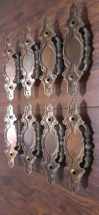 8 tiradores antiguos de metal patinado en bronce.