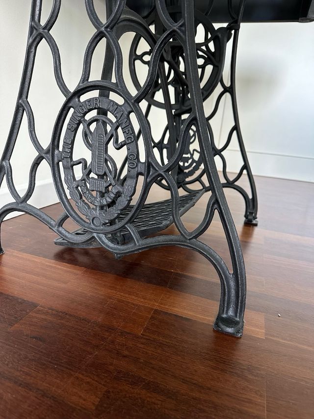 Mesa negra con pie de maquina de coser Zinger