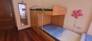 Habitación juvenil con literas y escritorio.