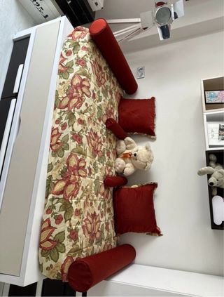 Colcha de flores y con cojines y cilindros a juego