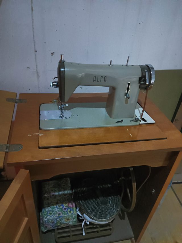 Màquina coser Alfa antigua con mueble y en uso.