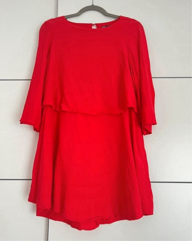 Vestido rojo corto, manga larga.