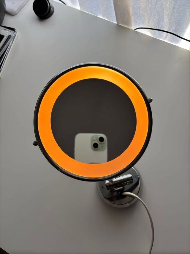 Espejo circular con luz de pared plata.