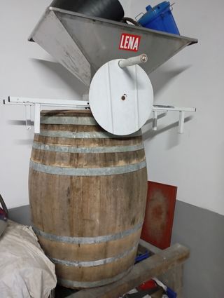 Desgranadora de uvas de inox y barriles.