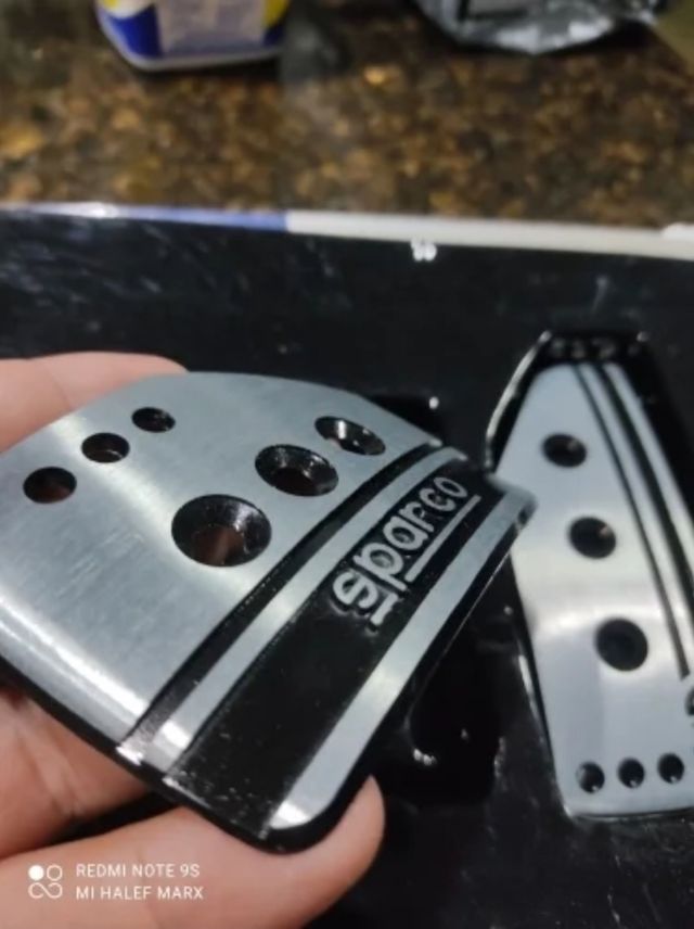 Pedales Sparco de aluminio con letras en negro.