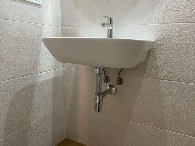 Lavabo blanco con sifón cromado