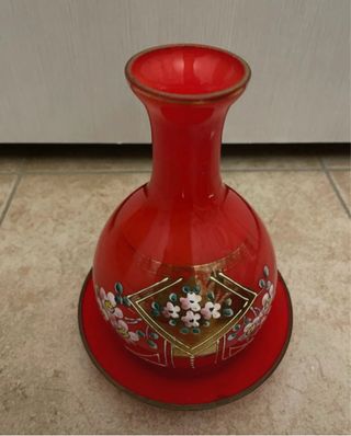 Bottiglia di vetro rossa con piattino