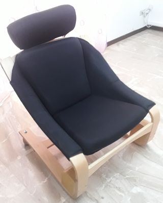 Poltrona in tessuto nero, poggiatesta regolabile.