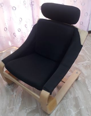 Poltrona in tessuto nero, poggiatesta regolabile.