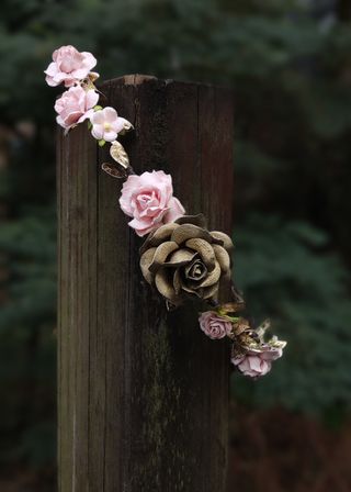 Corona de flores rosa empolvado y dorada