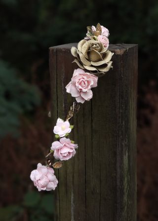 Corona de flores rosa empolvado y dorada
