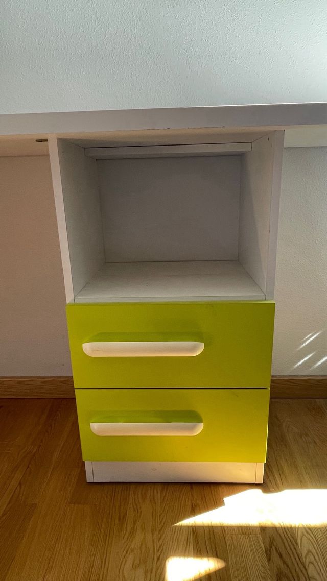 Mesa de estudio con cajones y estantería.