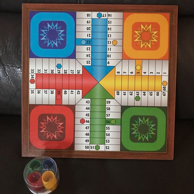 Tablero de madera de parchis y fichas