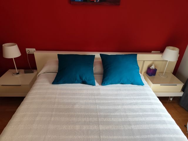 Cama matrimonio con cabezal y mesitas.