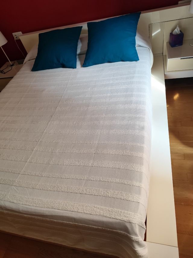 Cama matrimonio con cabezal y mesitas.