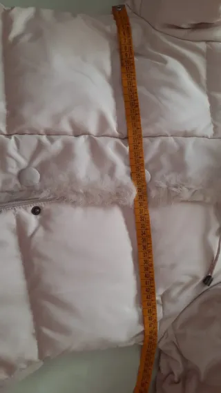 Cappotto in piuma con collo in pelo. Colore panna.