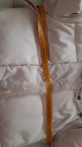 Cappotto in piuma con collo in pelo. Colore panna.