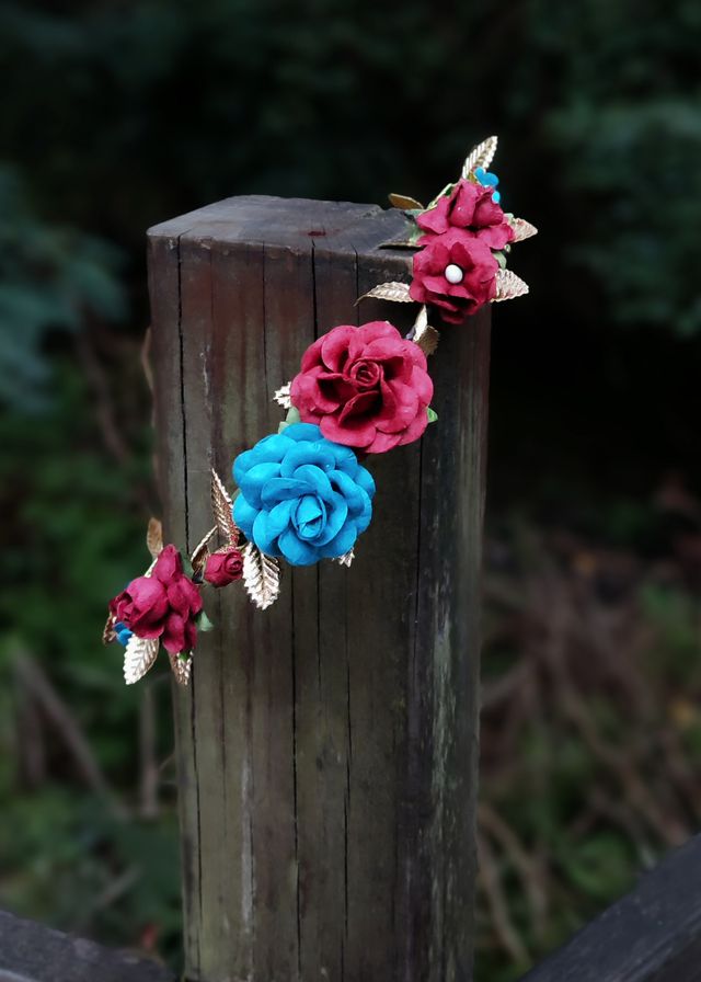 Corona de flores burdeos, azul y dorada