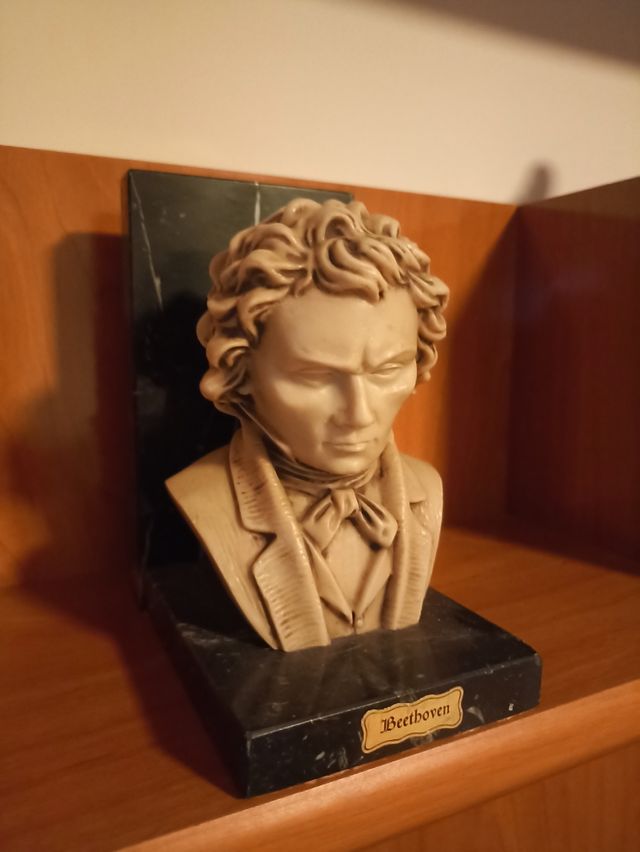 Busto de Beethoven sujeta libros de mármol.