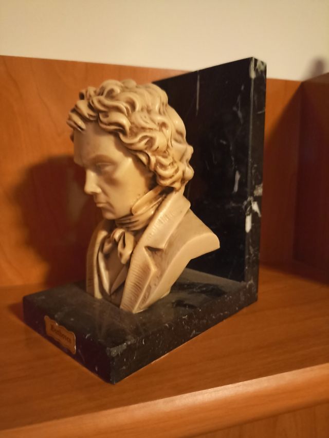 Busto de Beethoven sujeta libros de mármol.