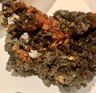 Minerale color rame anticato con cristalli bianchi