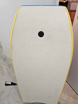 Tabla de surf y tienda para la playa.