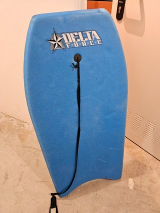 Tabla de surf y tienda para la playa.