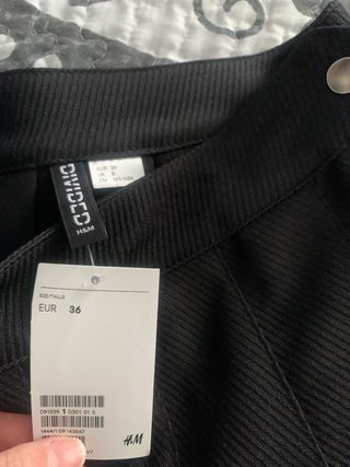 Falda con pliegues negro corto con etiquta