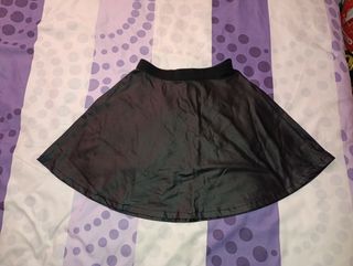 Falda de polipiel negra con borlas verde botella