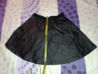 Falda de polipiel negra con borlas verde botella