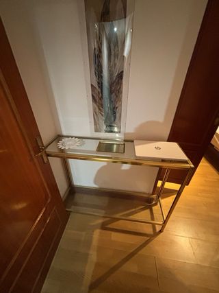 Conjunto de mesas de vidrio y metal dorado.