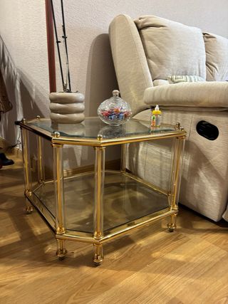 Conjunto de mesas de vidrio y metal dorado.