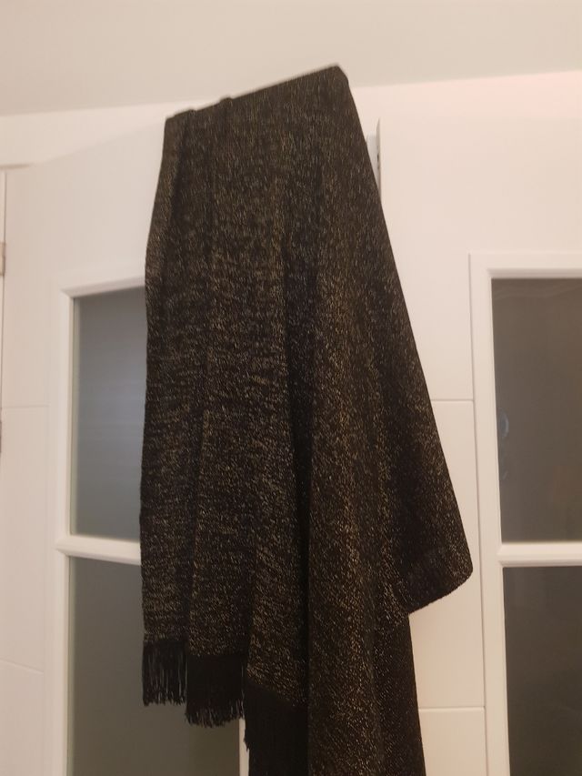 Chal de lana negro y brillos dorados.