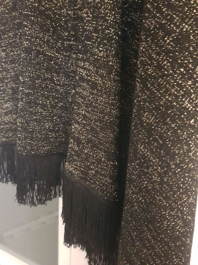 Chal de lana negro y brillos dorados.