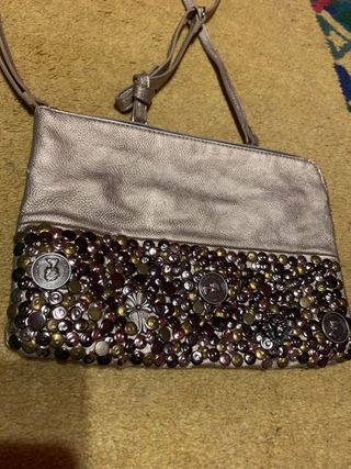 Bolso dorado con remaches de metal.