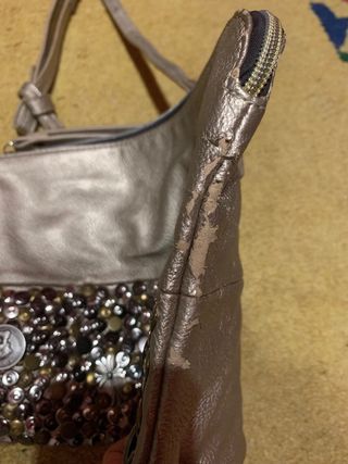 Bolso dorado con remaches de metal.