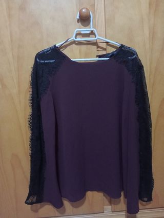 Blusa con encaje en hombro y mangas.
