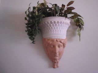 Escultura mujer jardinera pared plantas