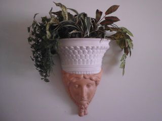 Escultura mujer jardinera pared plantas